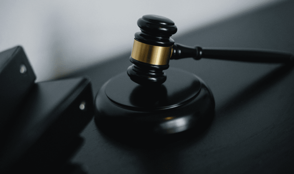 A judge's gavel resting on a sound block.